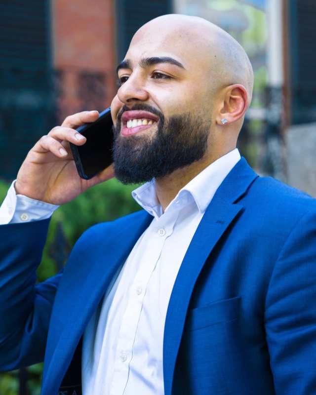 Xavier S. Cole, smiling, on a phone call outdoors